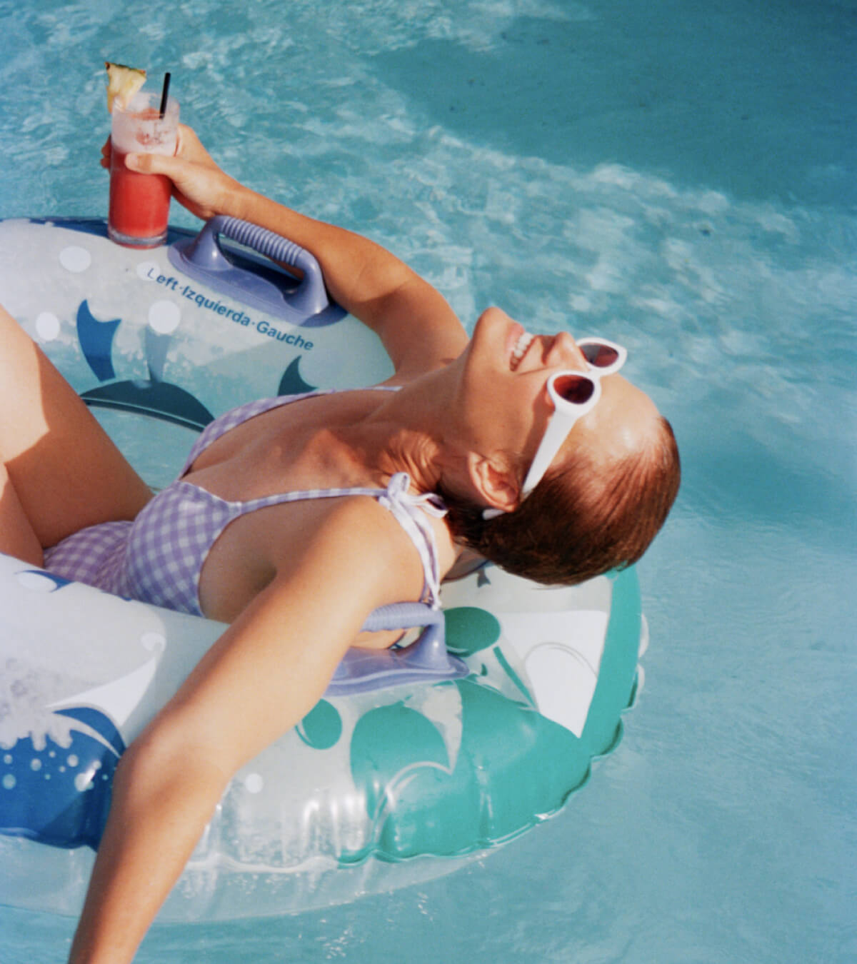 Girl is floating in the pool laying inside a round pool tube